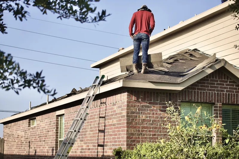 Professional roofer working on a residential roof in Green Meadows West
